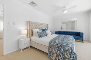 a bedroom with a blue bed and a blue couch at Riverfront on The Esplanade 3BDR in Perth