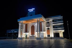 a building with a sign on top of it at night at Shivashish Resort in Indore