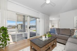 a living room with a couch and a table at Riverfront on The Esplanade 3BDR in Perth