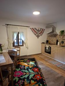a kitchen with a table and a dining room at Casa cu Poveste in Dorna Arini