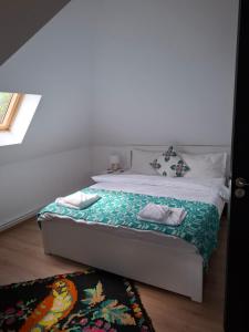 a bedroom with a bed with two pillows and a rug at Casa cu Poveste in Dorna Arini