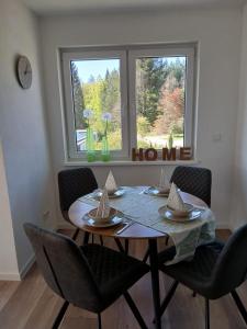 a dining room table with chairs and a window at Ferienwohnung Skulpturenweg in Ludwigswinkel