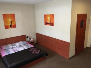 シュチェチンにあるStacja Grandのベッドルーム1室(ベッド1台付)が備わります。壁に2枚の写真が飾られています。