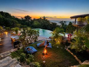 a group of people sitting around a fire in a pool at SANA Koh Phangan in Salad Beach