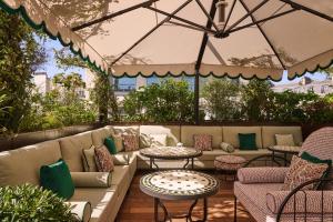 a patio with couches and tables and umbrellas at Hôtel Fouquet's Paris in Paris