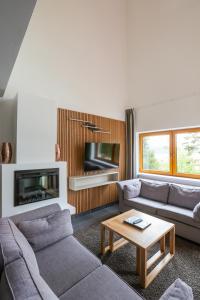 a living room with two couches and a coffee table at Lipno Lake Resort in Lipno nad Vltavou