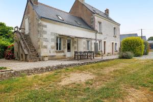 an old house with a table in front of it at Le Café de l'Encloître in Beaumont-la-Ronce