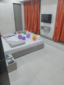 a room with a bed with colorful balls on it at hotel v heritage in Surat