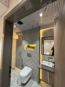 a bathroom with a toilet and a sink and a mirror at hotel v heritage in Surat