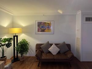 a living room with a couch and a painting on the wall at Canberra City View Apartment in Canberra