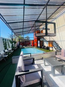 a patio with a pool and a table and a bench at Hotel El Infinito in Kempton Park