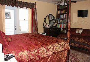 a bedroom with a red bed and a book shelf at GlenMorey Country House in Placerville