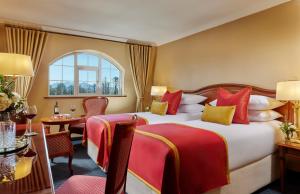 a hotel room with a bed with red and yellow pillows at Killarney Towers Hotel & Leisure Centre in Killarney