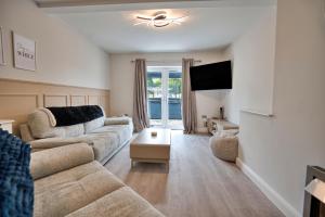 a living room with a couch and a tv at Finest Retreats - Dockyard House in Pembroke Dock