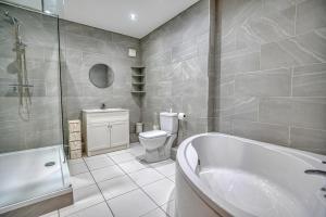 a bathroom with a tub and a toilet and a sink at Finest Retreats - Dockyard House in Pembroke Dock +16 photos