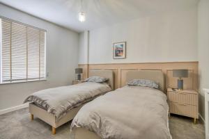 a bedroom with two beds and a window at Finest Retreats - Dockyard House in Pembroke Dock
