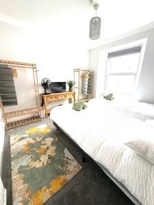 a bedroom with two beds and a rug at Joshua House in Newquay