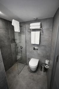 ein Badezimmer mit Toilette und Dusche sowie Handtüchern in der Unterkunft The Revia Square Hotel in Istanbul