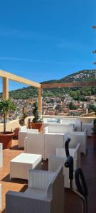 a balcony with white chairs and a view of a city at Relais Casa Spanu in Dorgali