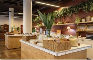 a store with a counter with baskets and plants on the wall at One Thibault Hotel - Business Studio in Cape Town