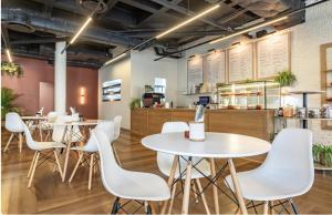 a restaurant with white tables and white chairs at One Thibault Hotel - Business Studio in Cape Town +15 photos