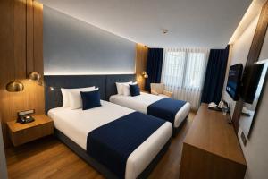 ein Hotelzimmer mit zwei Betten und einem Fernseher in der Unterkunft The Revia Square Hotel in Istanbul + 66 Fotos