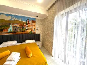 a bedroom with two beds and a painting on the wall at 7 Baits Hotel in Tbilisi City