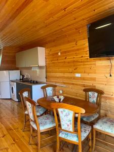 a dining room with a table and chairs and a kitchen at Cottage Sandro in Kobuleti +8 photos