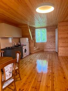 a large room with a kitchen and a dining table at Cottage Sandro in Kobuleti