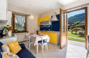 a kitchen with a table and a kitchen with yellow cabinets at Residenza Jasmine in Verbania