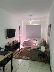 a living room with a couch and a bed at Apartamento Icônico em Petrópolis in Petrópolis