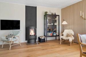 a living room with a fireplace and a tv at 30111-Odder-Lundgaardsvej-7 in Odder