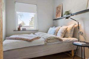 a bed with pillows and a window in a room at 30111-Odder-Lundgaardsvej-7 in Odder