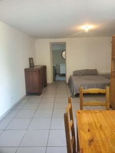 a bedroom with a bed and a table and chair at Studio Beau rêve in Le Cheylard