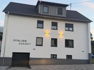a white building with lights on the side of it at Ferienwohnung Skulpturenweg in Ludwigswinkel +4 photos