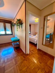 a room with a bedroom with a bed and a mirror at La casina de isa in Aller