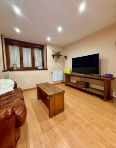a living room with a couch and a flat screen tv at La casina de isa in Aller