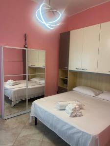 ein Zimmer mit zwei Betten und einem Spiegel in der Unterkunft Dimora Morge in Policoro