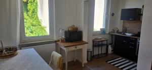 a kitchen with a small desk with a television on it at Cozy city appartement in Forchheim