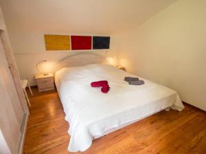 a bedroom with a white bed with a red shirt on it at Fernblick Appartement Simonhöhe in Zirkitz +46 photos