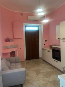 ein Wohnzimmer mit Sofa und eine Küche in der Unterkunft Dimora Morge in Policoro + 4 Fotos