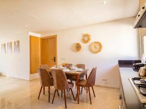 a dining room with a table and chairs at Ocean View Duplex & Golf, Taghazout Bay in Tamraght Ouzdar