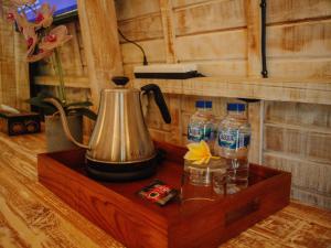 a tea kettle and water bottles on a wooden shelf at Griyani Homestay in Uluwatu
