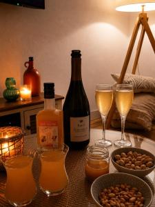 a table with two glasses of wine and wine bottles at Appartement vue imprenable sur la Loire !!! in Saumur +33 photos