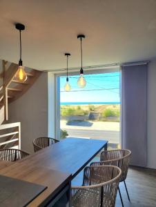 a dining room with a large table and chairs at Villa les pepouzes - vue mer - jacuzzi- sauna in Plouescat