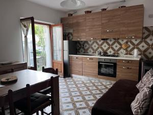 a kitchen with wooden cabinets and a table and a dining room at A due passi dai lupi in Civitella Alfedena