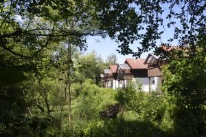 a building in the middle of a field with trees at Ferienwohnung Wildgatter in Grafenwiesen