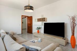 a living room with a large flat screen tv at Uga La Dehesa I in Uga