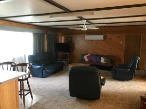 a living room with a couch and a table and chairs at Lakeside Chalet & Studio in Beechworth