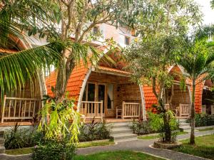 a house with an orange roof and some trees at Griyani Homestay in Uluwatu